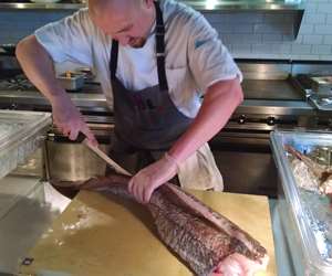 Chef cutting and cleaning a filet of fish