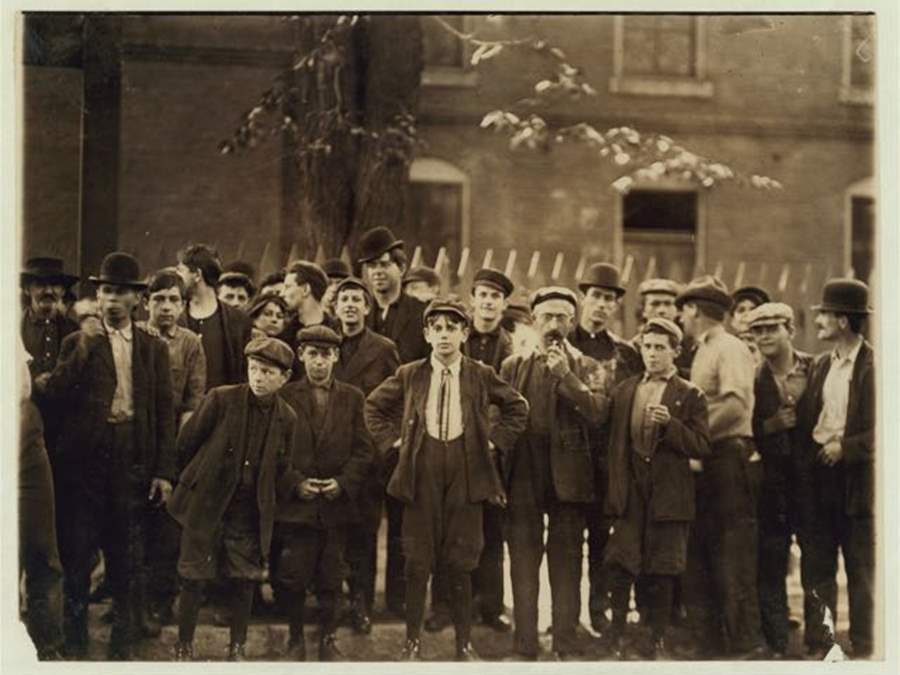 Factory workers, young and old, gathered outside of one of the mills