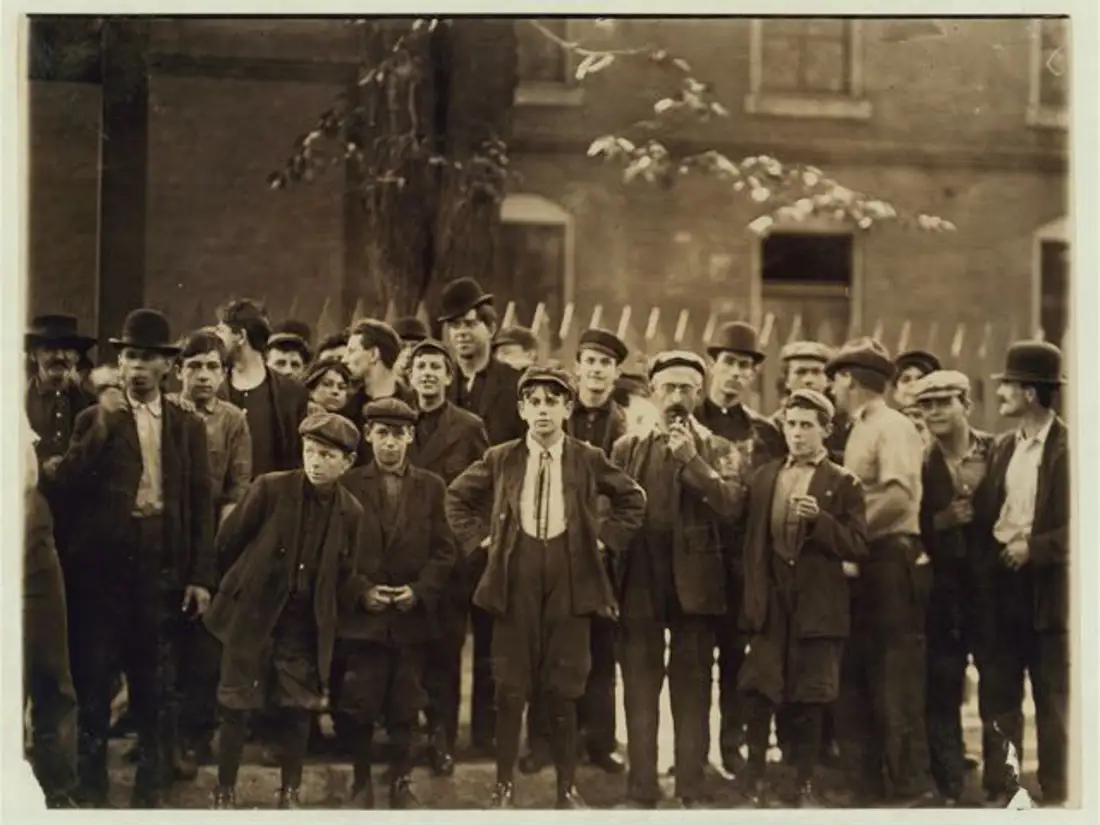 Factory workers, young and old, gathered outside of one of the mills