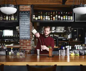 Sam Nelis, original bar manager, making drinks behind the bar