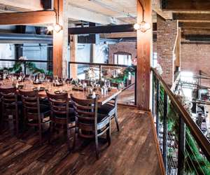 Loft set up for a holiday event. One long table and garland along the railing