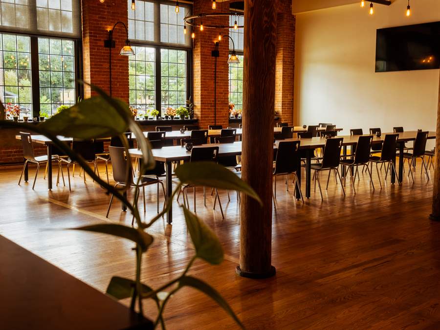 Waterworks' River House from a different angle with tables parallel to the Winooski River, facing the TV