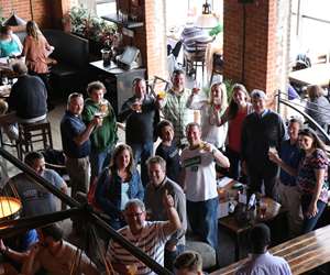 Bird's eye picture of guests in the lounge with raised glasses, taken from the Loft