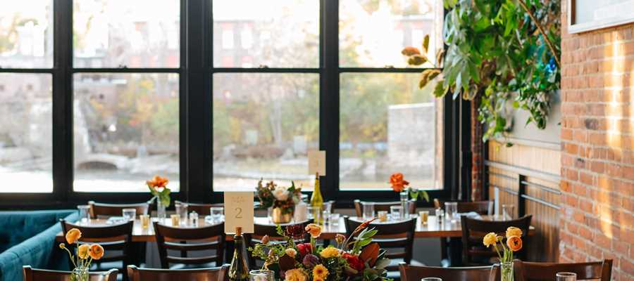 Waterworks' Greenhouse dining room is shown setup with large tables for a wedding reception.