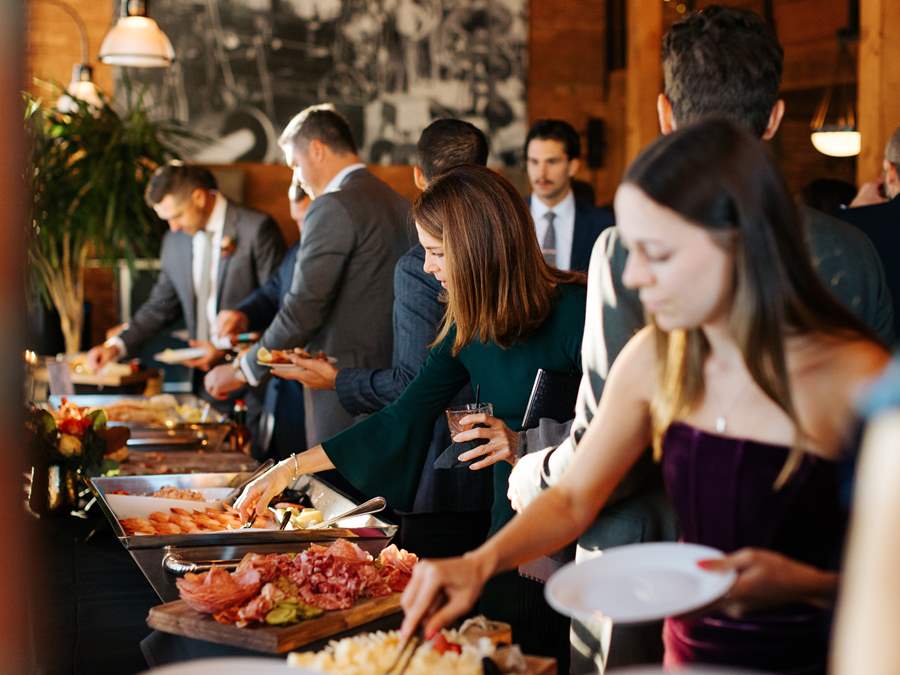 Event guests help themselves to a beautiful assortment of stationary boards and hors d'oeuvres.