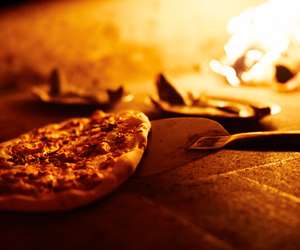 Flatbread being pulled out of the wood fire oven