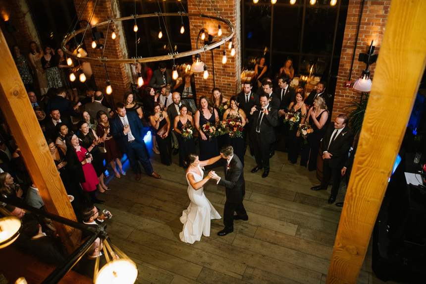 Bird's eye view of a couple during their first dance with wedding guests surrounding them