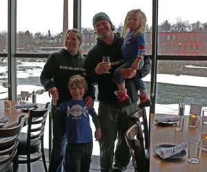 Guests posing in the Solarium with Winooski River in the background